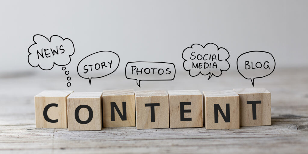 Content wording on wooden cubes with speech bubbles. wooden blocks spell out the word content with word bubbles above that say news and stories and photos and blog